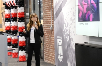 photo of woman presenting, with microphone and screen