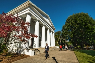 photo of people walking on sidewalk near classical building 