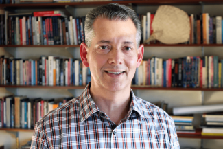 photo of man with books in background