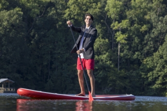 photo of man in coat and tie on lake