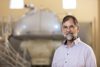 photo of man with lab equipment in background