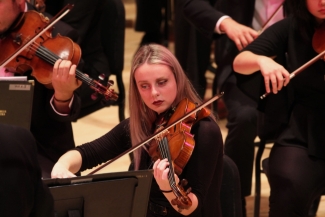 photo of woman playing viola, with other musicians