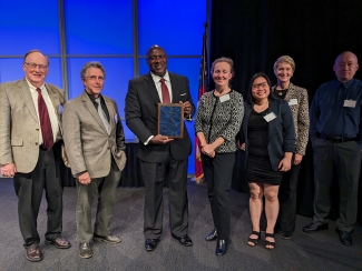 group photo of seven people on stage