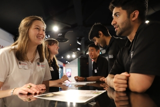 photo of people talking cross desk