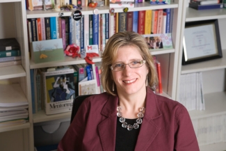 photo of woman sitting in front of bookshelves