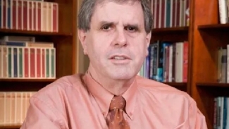 photo of man with books in background