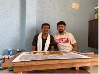 photo of two men, with drawing on table