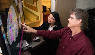 photo woman and man pointing to computer screen