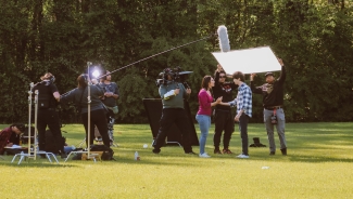 photo of people working on film set, outdoors, day