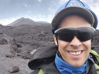 photo of man with volcanic mountain in background