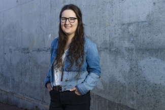 photo of woman standing against concrete wall