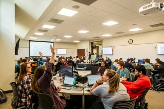 photo of people in classroom, with computers and projection screen