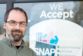 man next to a window sign