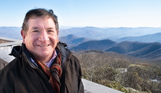 photo of man with mountains in background