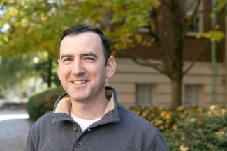 photo of man outside, with building, day