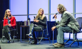 photo of three people on a stage with microphones