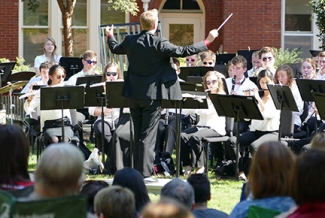 musicians playing outside, with spectators in foreground