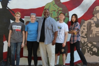 people standing in front of a painted mural