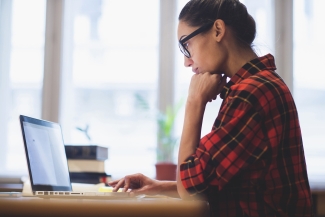 photo of woman standing with laptop computer