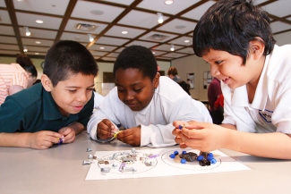 photo of three boys working together in classroom