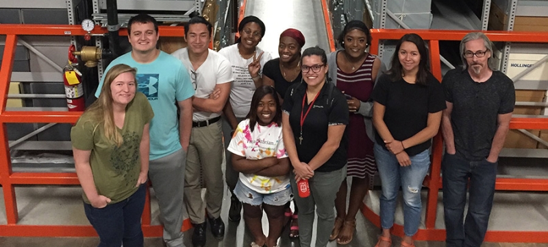 Photo of ten people in a warehouse interior