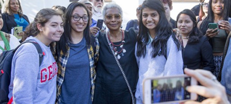 woman with students posing for photos
