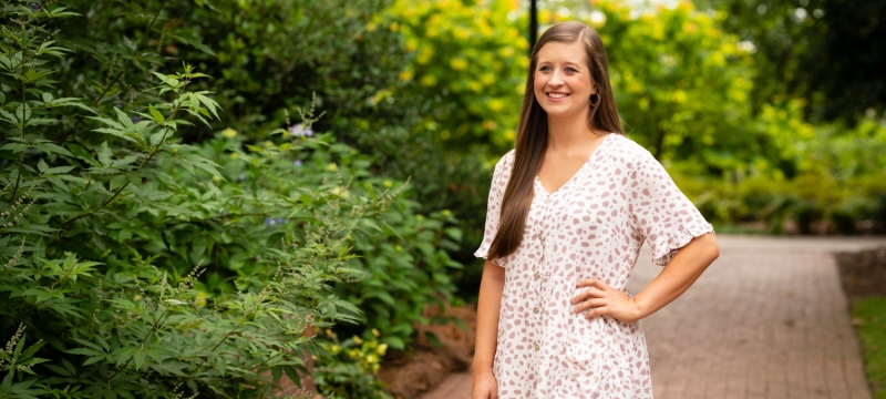 photo of woman standing on brick sidewalk