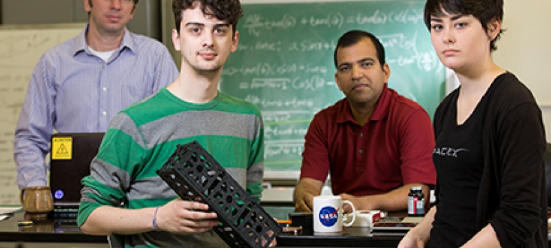 four people in a lab, with model