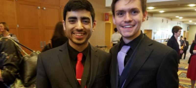 two men in a lobby with medals
