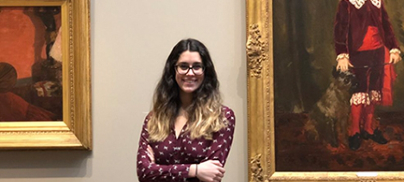 photo of woman with framed paintings