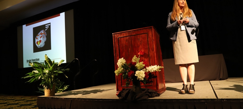 photo of woman next to podium on dais