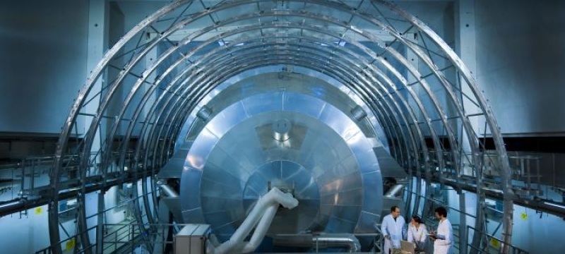 Photo of large metallic equipment and three people