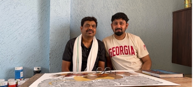 photo of two men, with drawing on table