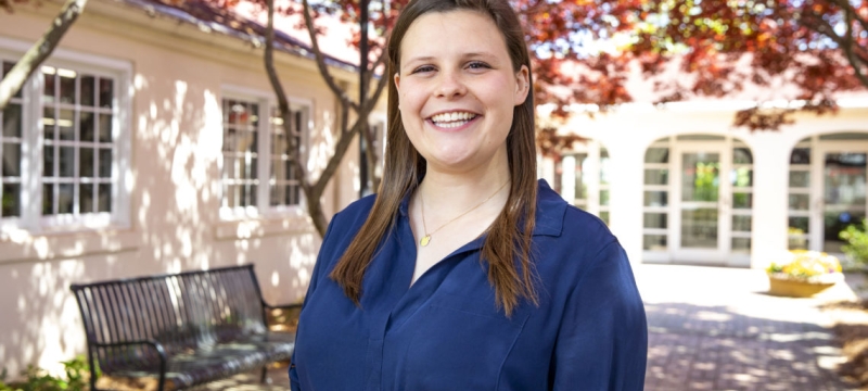 photo of woman outside of building with trees