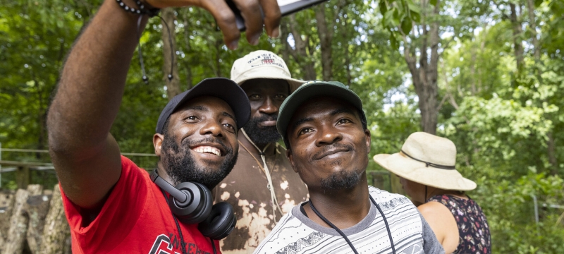photo of three men taking a selfie, with trees, day