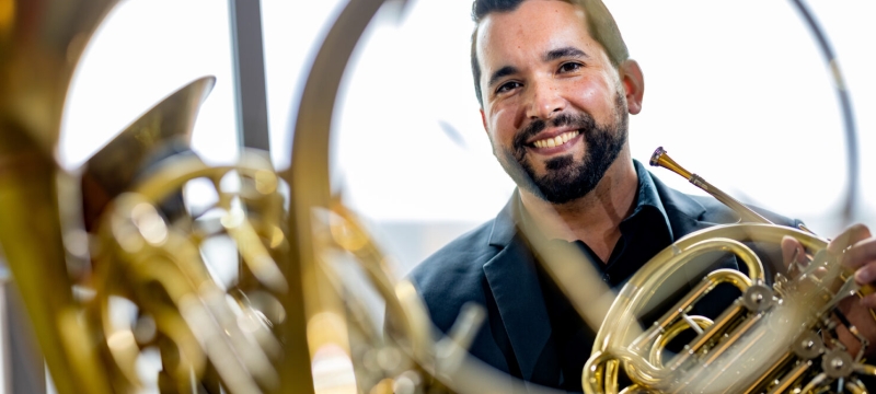 photo reflection of man with horn instrument