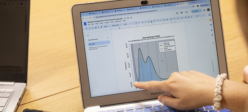 photo of hand pointing at laptop computer