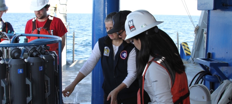 photo of five people with sensor gear on boat, ocean in background, day