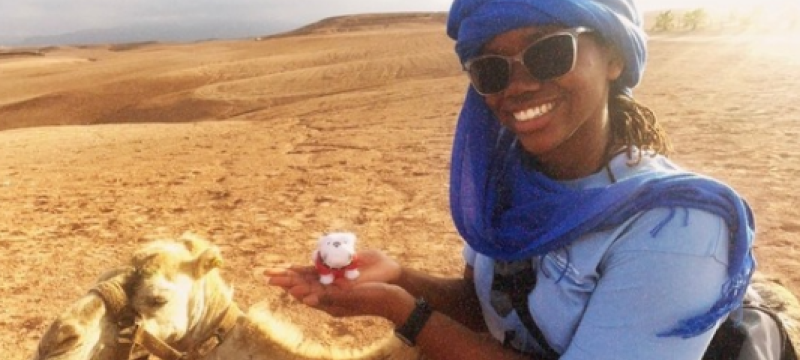 photo of woman with camel, desert in background