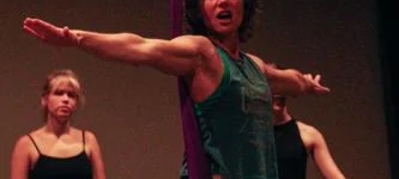 photo of woman arms extended, with two people in background