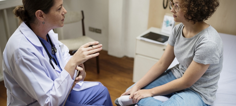 photo of doctor and young patient talking