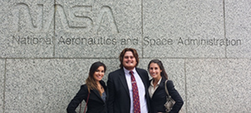 three students in front of NASA sign
