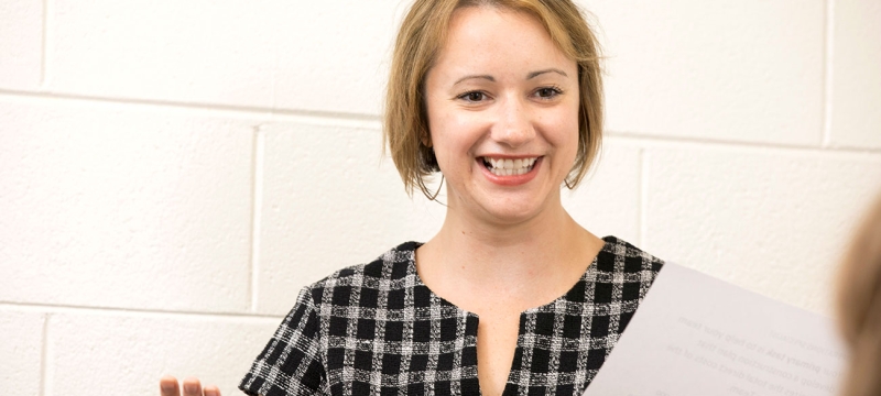 photo of woman holding paper, indoors