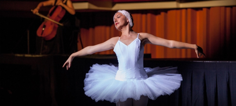 photo of ballerina, with cellist in the background