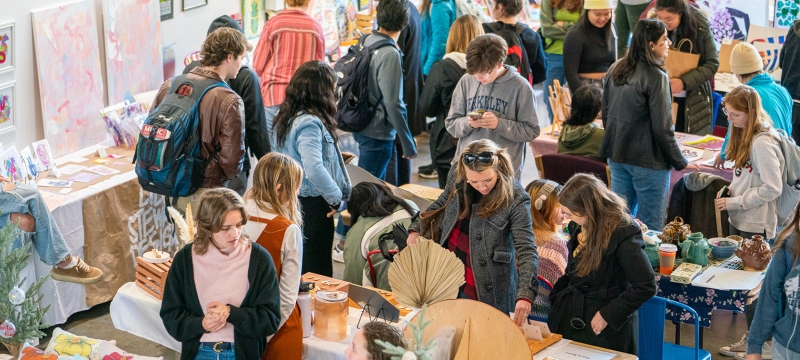 photo of people, tables and objects at an artist's market
