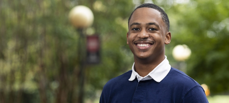 Photo of man in blue shirt outdoors, day