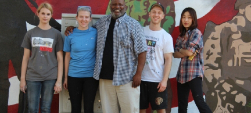 people standing in front of a painted mural
