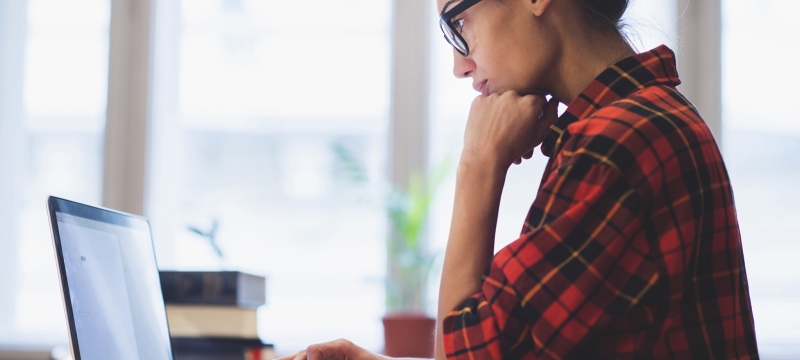 photo of woman standing with laptop computer