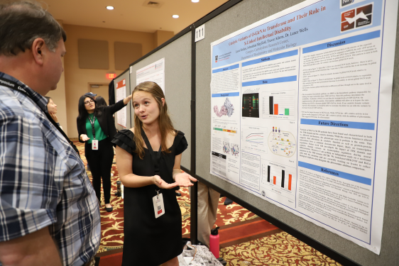 photo of people speaking in front of posters, ballroom