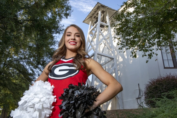 photo of cheerleader in front of the chapel bell